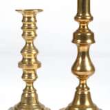 2 diverse Messing-Leuchter, 1. Hälfte 19. Jh., 1-kerzig, gegliederter Schaft, 1x instabil, H. 21 cm und 25 cm - photo 1