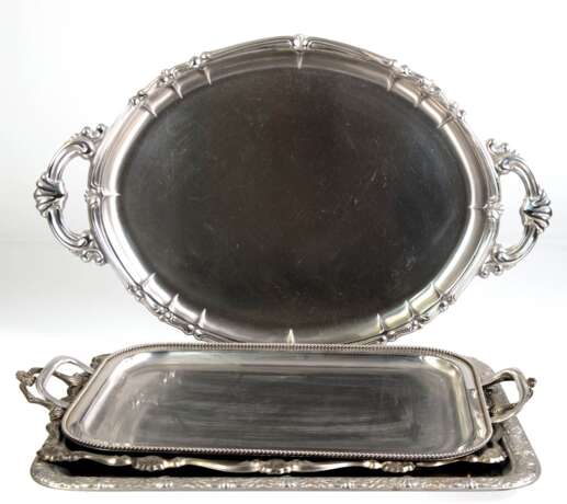 4 diverse Tabletts, Weißmetall, teils versilbert, 3x mit 3 seitl. Henkeln, L. 53 cm, 56 cm, 63 cm und 49x38 cm - photo 1 4 diverse Tabletts, Weißmetall, teils versilbert, 3x mit 3 seitl. Henkeln, L. 53 cm, 56 cm, 63 cm und 49x38 cm - photo 1