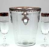 Sekt/ Weinkühler, Klarglas, reliefierter Metallrand mit 3 Abhängungen mit Steinen besetzt, H. 22 cm, Dm. 19 cm dazu 4 Sektgläser, farbloses Glas mit Goldrand (berieben) und umlaufendem Blütendekor, Rundfuß, Stiel mit ged… - Foto 1