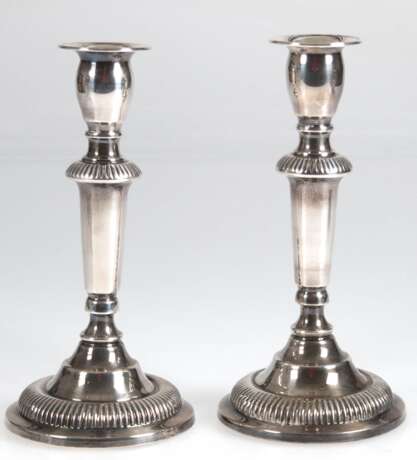 Paar Leuchter, 830er Silber, 1-kerzig, gefüllter, getreppter Rundfuß in gegliederten Schaft übergehend, 2 Zierfriese mit Rillendekor, vasenförmige Tülle, H. 19 cm - photo 1 Paar Leuchter, 830er Silber, 1-kerzig, gefüllter, getreppter Rundfuß in gegliederten Schaft übergehend, 2 Zierfriese mit Rillendekor, vasenförmige Tülle, H. 19 cm - photo 1