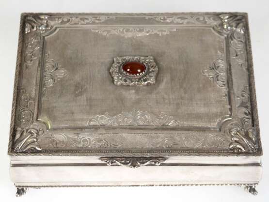 Schatulle, 800er Silber, Italien, auf 4 reliefierten Füßchen, reich verzierter und fein strukturierter Scharnierdeckel mit ovalem Karneol-Cabochon, Ges.-Gew. 574 g, 6x16,5x12,5 cm - photo 1 Schatulle, 800er Silber, Italien, auf 4 reliefierten Füßchen, reich verzierter und fein strukturierter Scharnierdeckel mit ovalem Karneol-Cabochon, Ges.-Gew. 574 g, 6x16,5x12,5 cm - photo 1