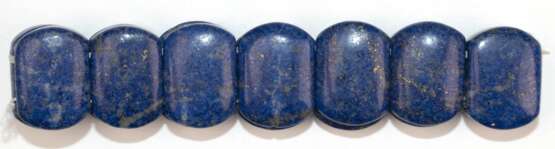 Lapislazuli-Armband, 14 flexibel aufgezogen, Gew. 35,14 g. Dm. ca. 6,5 cm, B. 1,8 cm - фото 1 Lapislazuli-Armband, 14 flexibel aufgezogen, Gew. 35,14 g. Dm. ca. 6,5 cm, B. 1,8 cm - фото 1