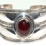 Armreif mit rotbraunem Cabochon, 928er Silber, breite offene Schien mit Kordeldekor, kl. Delle, Ges.-Gew. 34,73 g, Innen-Dm. 5,9 cm, B. 4,0 cm - photo 1