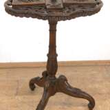 Gründerzeit-Rauchtisch, Nußbaum, reich floral beschnitzt, durchbrochene vierpassige Platte mit eingearbeitetem Aschenbecher, Kerzenleuchter, Zigarren-, Zigaretten- und Streichholzdose, Platte mit Riß, ges. 90x54x43 cm… - photo 1