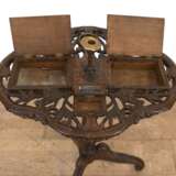 Gründerzeit-Rauchtisch, Nußbaum, reich floral beschnitzt, durchbrochene vierpassige Platte mit eingearbeitetem Aschenbecher, Kerzenleuchter, Zigarren-, Zigaretten- und Streichholzdose, Platte mit Riß, ges. 90x54x43 cm… - photo 2
