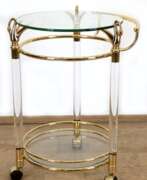 Meubles. Servierwagen, Messinggestell auf Rädern mit 2 runden Glasböden, 3 Kunststoffsäulen, H. 69 cm, L. 54 cm