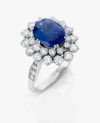 Bijoux de main. An entourage ring with sapphire and brilliant-cut diamonds