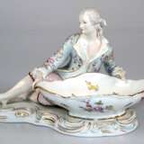 Figur "Kavalier an Schale sitzend", in der Art von Meissen, wohl Gebr. Voigt Porz.-Manufaktur Sitzendorf um 1900, polychrom bemalt mit Goldstaffage (etwas berieben), gekreuzte blaue Linien, Knie min. best., H. … - Foto 1