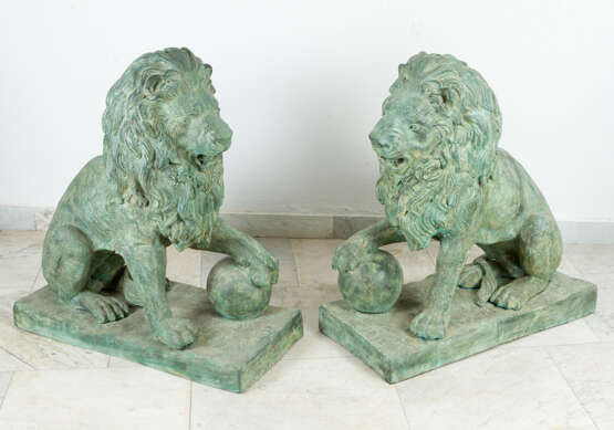 Pair of large bronze lions in sitting position with ball in paw on rectangular integrated bases - photo 1