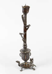 Asian candlestick in form of a flower with leaves on a vase with fantastic animals