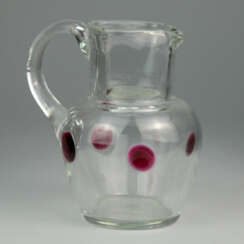 Glaskrug mit Rotglas-Einschmelzungen und Ohrenhenkel, Handarbeit, 19. Jahrhundert, sehr gut.