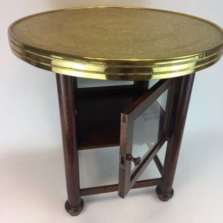 Runder Tisch / Couch-Tisch: Runde Platte mit Messing-Montur, gerade Beine mit verglastem Unterfach, um 1930, sehr gut. - photo 1