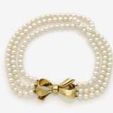 Dreireihige Perlenkette mit schleifenförmiger Goldschließe - Foto 1