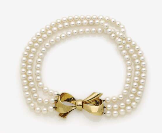 Dreireihige Perlenkette mit schleifenförmiger Goldschließe - Foto 1