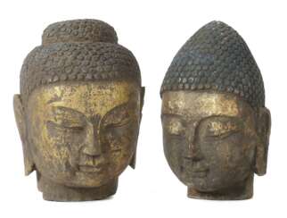 2 Buddhaköpfe Südostasien, Stein, vergoldet, je Kopf eines Buddhas mit gesenktem Blick und langen Ohrläppchen, H
