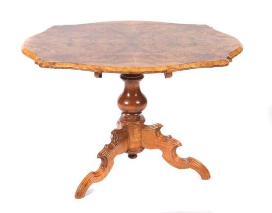 Louis Philippe-Tisch um 1860, 3 geschweifte Beine, 1 Balustersäule, aufgeschraubte Tischplatte in angedeuteter Ovalform mit geschweiften Ecken, die Platte mit vierfach geklapptem, lebhaftem Nussbaummaserfurnier, HxBxT - фото 1