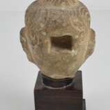 Steinkopf des Buddha auf einem Holzsockel - фото 3