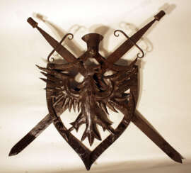 Iron coat of arms, Austrian iron wall emblem, forged iron with eagle and two removable swords in shield shaped frame, partly chased, one hanging ring on the reverse