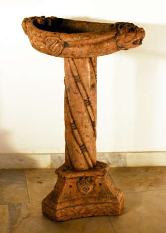 A rosso verona pidgeon or central standing fountain on triangle shaped base with central turned and fluted column and oval basin, on the sides with lion heads, volutes and a coat of arms - Foto 1