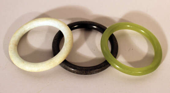 Three Asian jade bracelet in green, white and black colours, polished. - photo 1