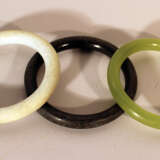 Three Asian jade bracelet in green, white and black colours, polished. - фото 1