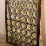 A mouth blown window with round partly coloured glass in tin net with iron wind protection in wooden frame - фото 3