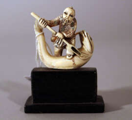 Japanese ivory netsuke with a man standing on a fish with fine engravings and signature on the fish