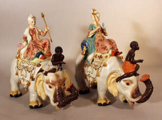A pair of porcelain elephants with a queen and a king with servants on top