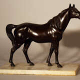 Bronze sculpture of a standing horse looking to the side, on white marble base - photo 1