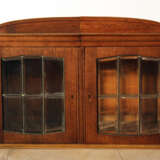 A Jugendstil display cabinet with arched top, two doors and cutted glass windows with bronze grid - фото 1