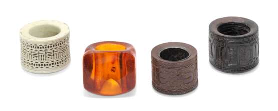 A GROUP OF FOUR AMBER, PORCELAIN AND WOOD ARCHER'S RINGS - photo 1