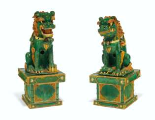 A PAIR OF MASSIVE TILEWORKS FIGURES OF SEATED BUDDHIST LIONS...