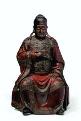 A LARGE CARVED AND LACQUERED WOOD FIGURE OF A SEATED OFFICIA...