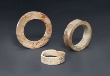 THREE OPAQUE IVORY-COLORED AND CARAMEL-BROWN JADE BRACELETS ...
