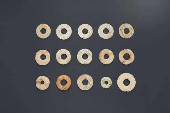 A GROUP OF FIFTEEN IVORY-COLORED JADE DISCS - photo 1