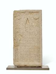 A CARVED WHITE LIMESTONE TOMBSTONE