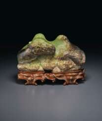 A LARGE OLIVE-GREEN AND DARK BROWN JADE FIGURE OF A RECUMBEN...