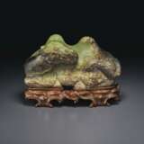 A LARGE OLIVE-GREEN AND DARK BROWN JADE FIGURE OF A RECUMBEN... - фото 1