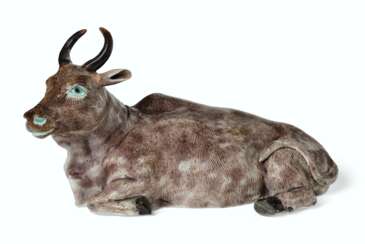 AN ENAMELED BISCUIT FIGURE OF A RECUMBENT WATER BUFFALO