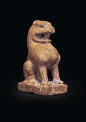 AN AMBER-COLORED STONE FIGURE OF A SEATED LION