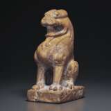 AN AMBER-COLORED STONE FIGURE OF A SEATED LION - photo 2