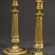Paar feuervergoldete Bronze Leuchter auf rundem Fuß mit kannelierten Schäften und ornamentalen Friesen, Frankreich 19.Jh., H. 24,5cm, Druckstellen - photo 1