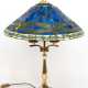 Tischlampe im Tiffanystil, 2. Hälfte 20. Jh., 3-flammig, gegliederter Messingfuß auf sechseckigem Stand, Schirm aus farbigem Kunstglas mit umlaufendem Libellendekor, H. 70 cm, Dm. 53 cm - фото 1