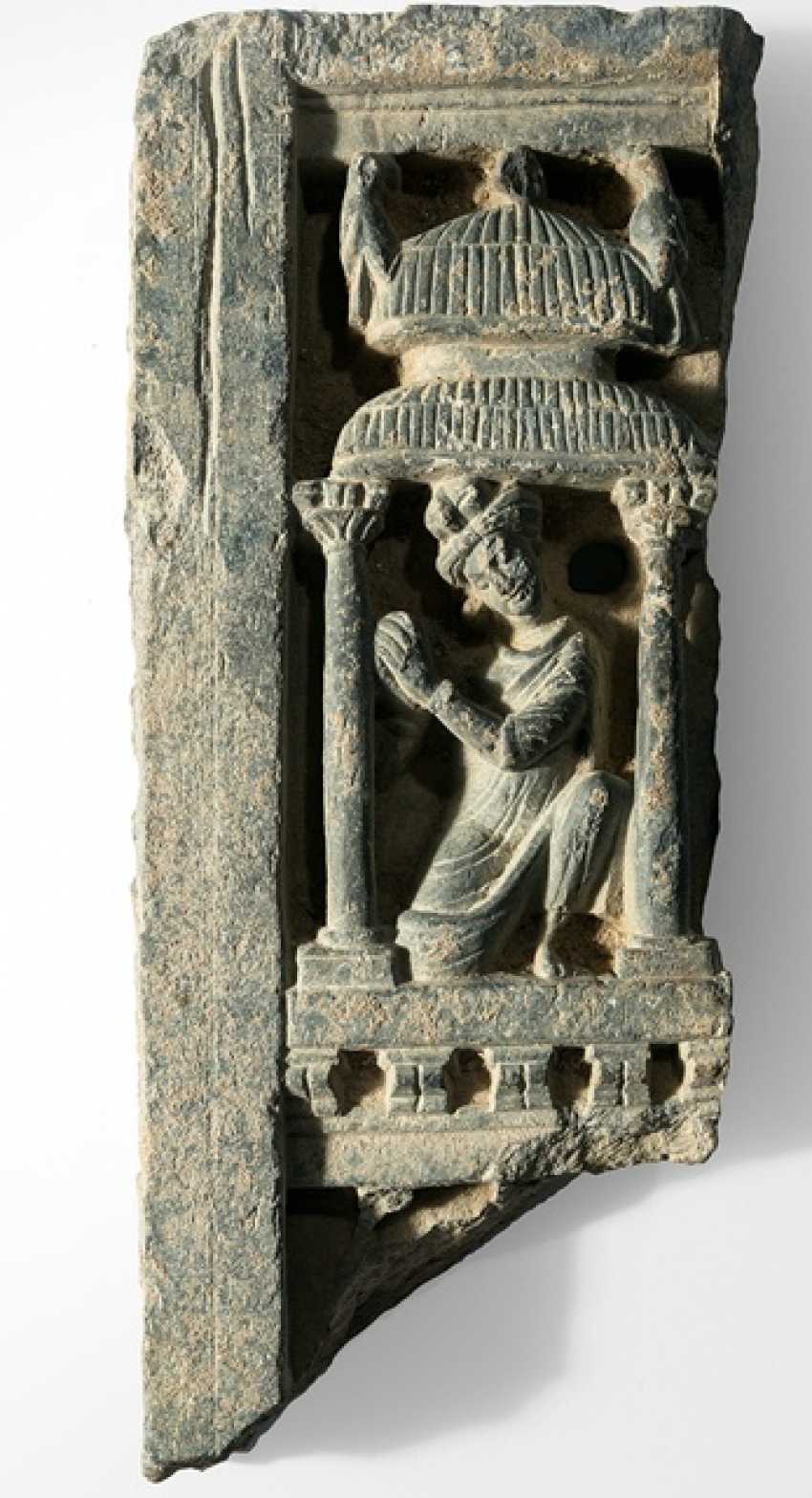 Fries aus grauem Schiefer mit Darstellung eines Mannes unter einem