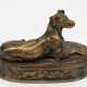 Bronze-Figur "Liegender Hund", auf ovalem Sockel mit umlaufenden Tierdarstellungen, nach F. Barbedienne Fondeur, auf Sockel bezeichnet, H. 10 cm, L. 16 cm - фото 1