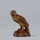 A CARVED WOOD NETSUKE OF A HAWK PERCHED ON A ROCK - Foto 1