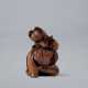 A CARVED WOOD NETSUKE OF A FOX (KUZUNOHA) HOLDING A CHILD - Foto 1