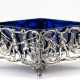 Kleine Jardiniere mit blauem Glaseinsatz, 925er Silber, rhombenförmig auf 4 Füßchen, figürlich durchbrochene Wandung mit Darstellungen von Eisvergnügen, seitlich 2 figürliche Henkel, Gew. (ohne Einsatz) 57 g, ges. 7x7,5x… - Foto 1