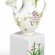 Kleine Gießkanne und Miniatur Blumentopf mit blühender Pflanze - Foto 1