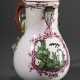 Fayence Kanne mit Balusterkorpus auf eingezogenem Fußring und plastischem Blattdekor an Asthenkel, feine kupfergrüne Watteau Malerei in Purpur Rocaillekartusche, Mitte 18.Jh., H. 22,2cm, best. - photo 1
